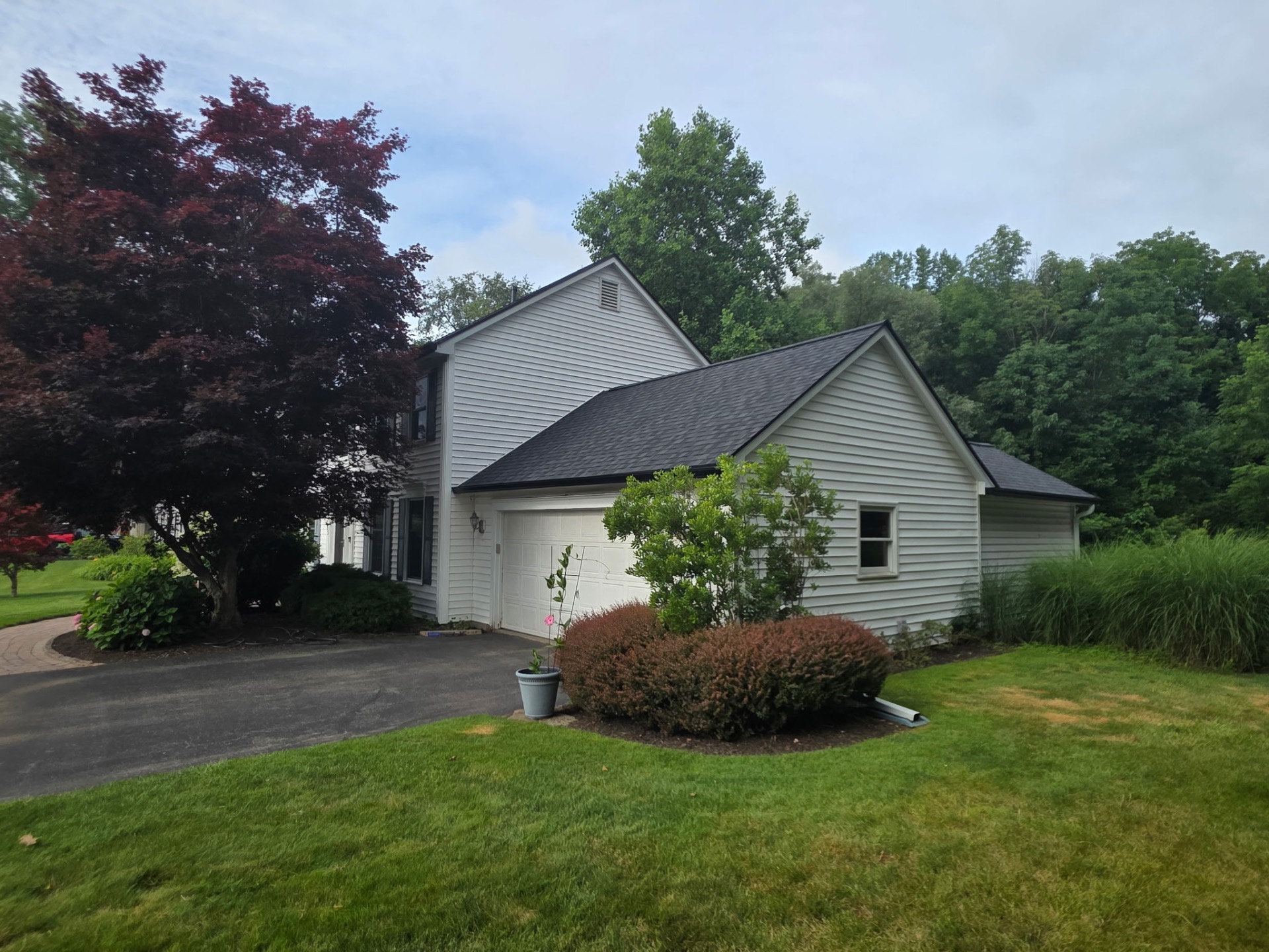 Fresh install — Max Def Moire Black with 6" black seamless gutters & white downspouts