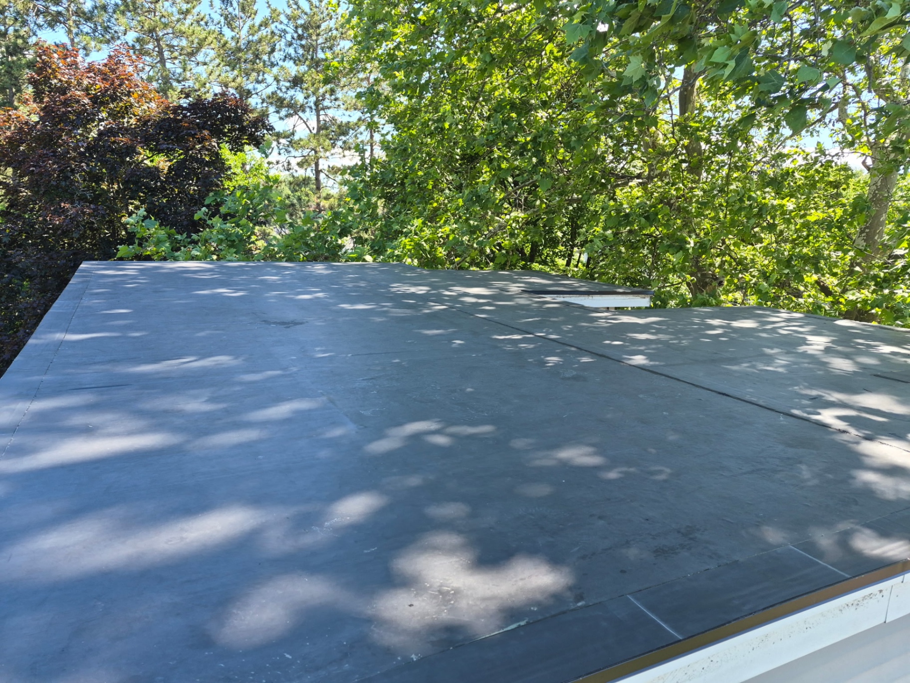 After — EPDM rubber roof replacement — worn, weathered membrane swapped for fresh seamless EPDM